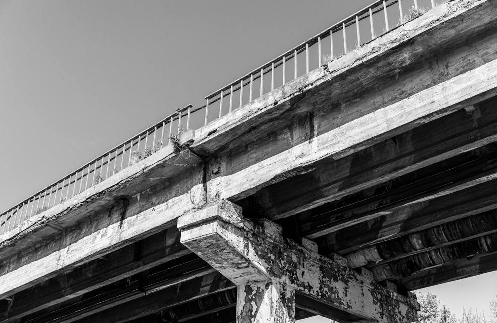Weathered concrete bridge showing signs of degradation and wear.